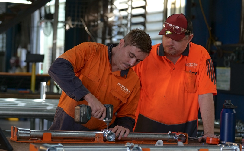 Two Moddex production team members applying finishing touches to the handrail manufacturing process.