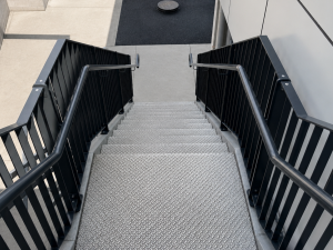 Powder-coated Moddex Flat Bal flat bar balustrades with offset Assistrail handrails installed on DDA-compliant access stairs, providing safe and accessible movement between levels.